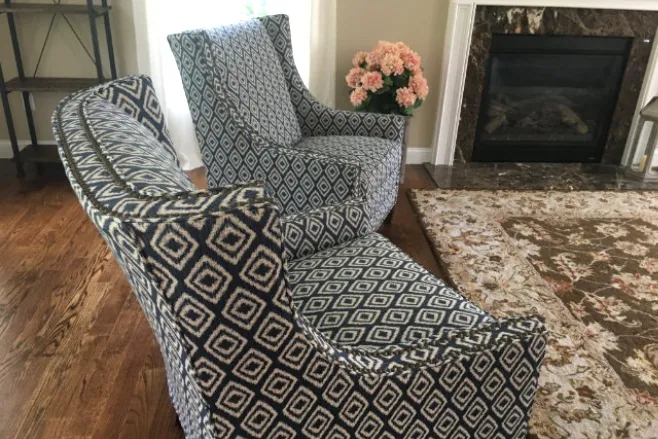 reupholstered patterned chairs by a fireplace
